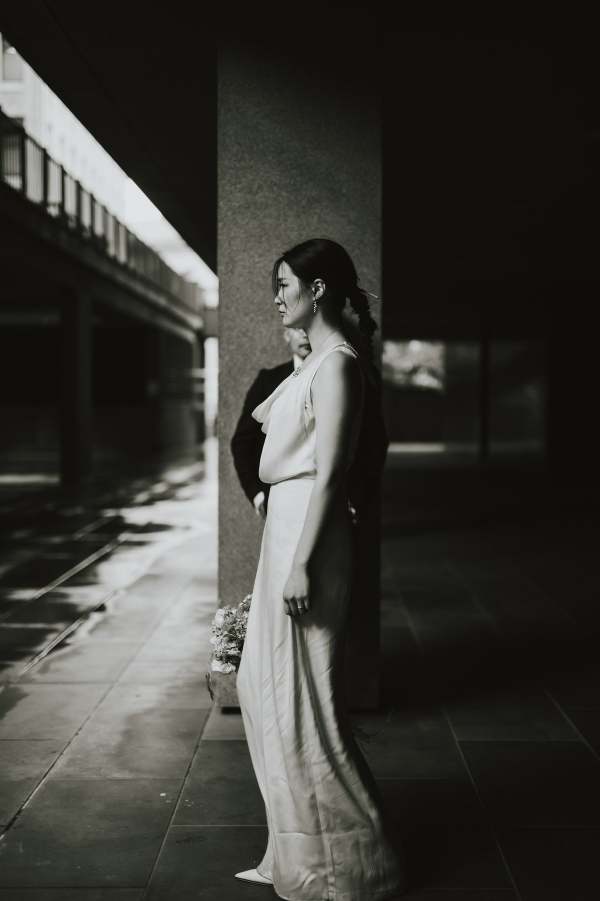 Bride posed in high-contrast architectural light