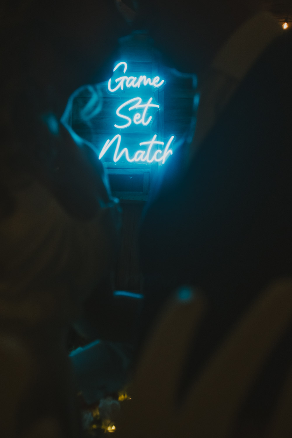 Personalised Game Set Match light photographed through the space between the couple