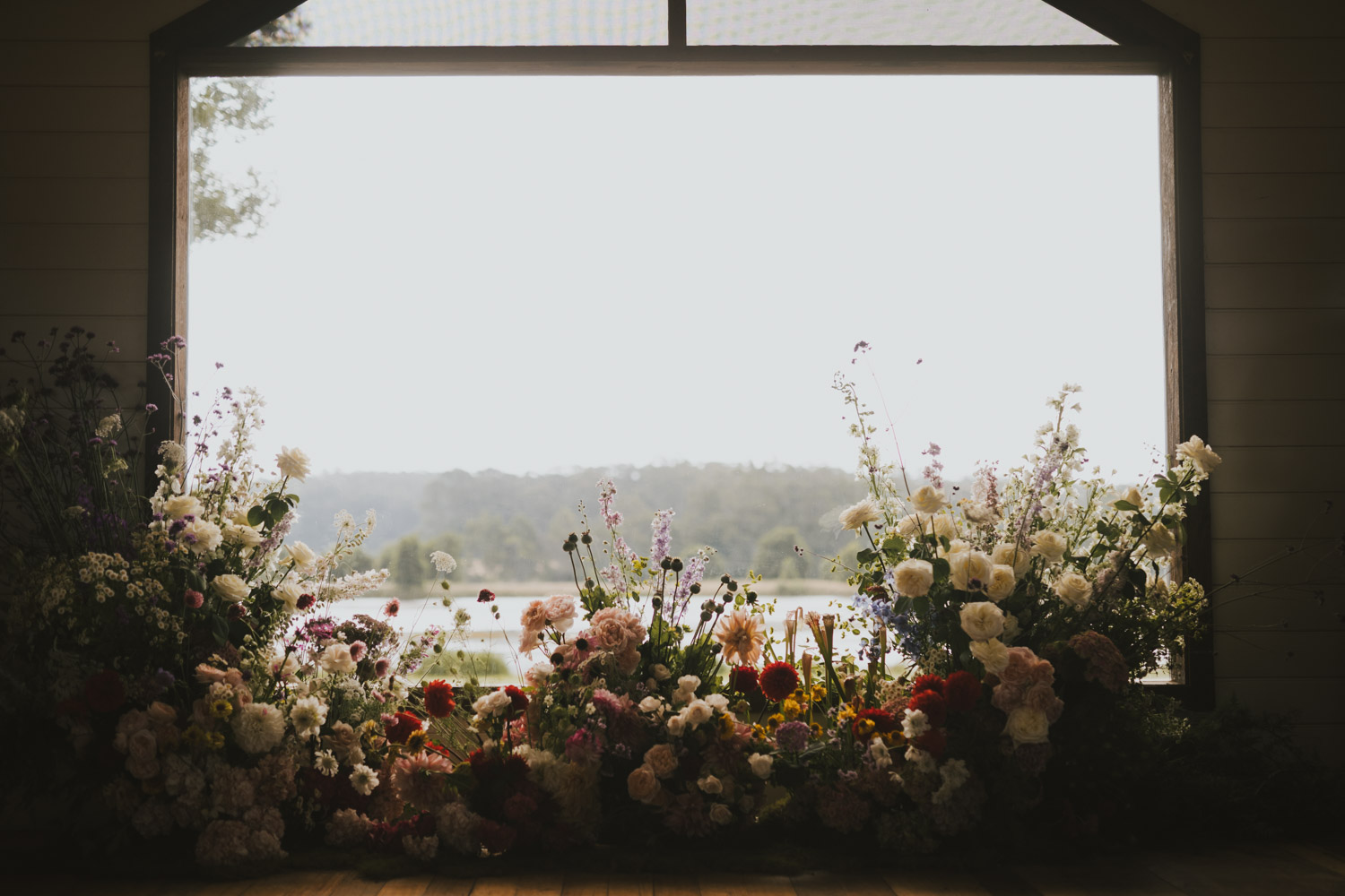 Floral ceremony installation framed by a bright window