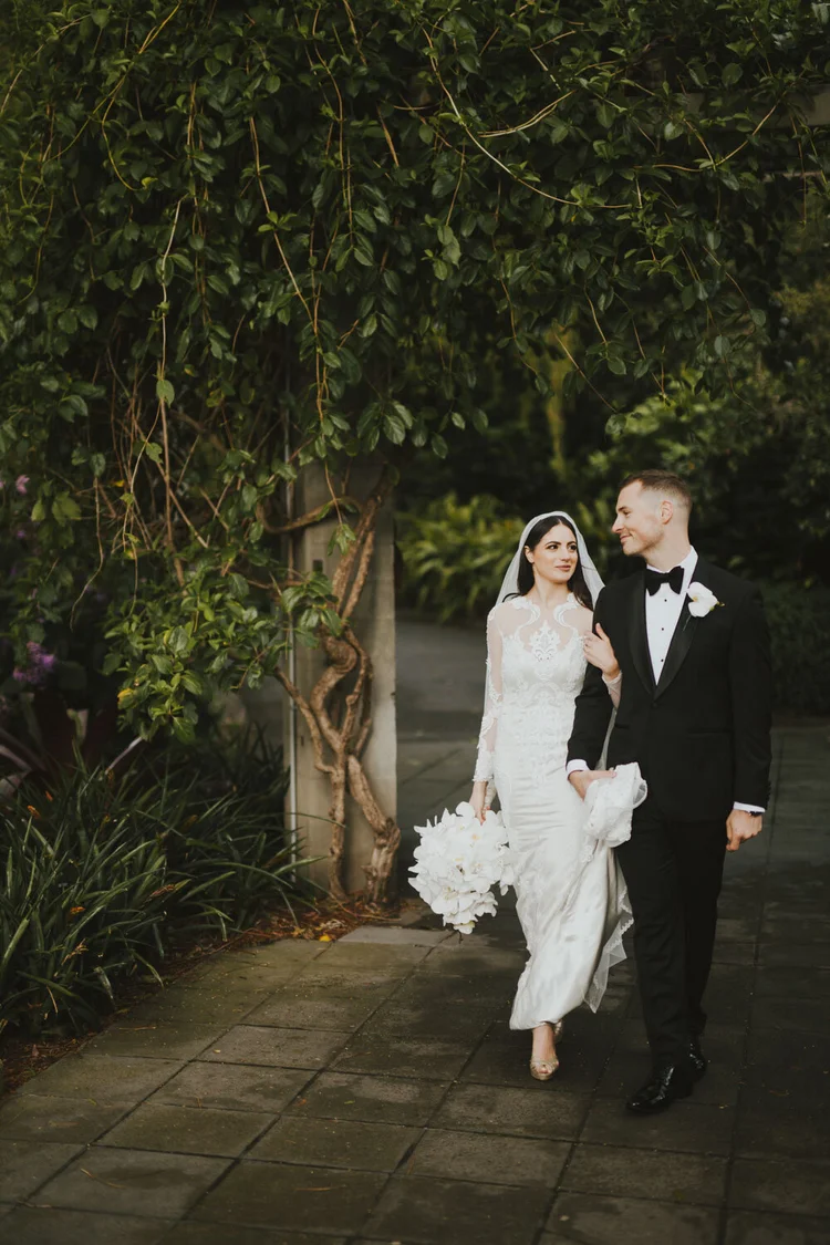 Couple walking through deep green foliage