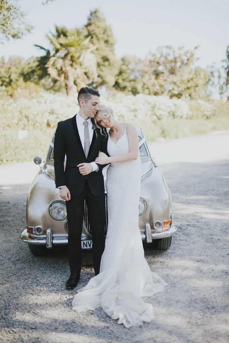 Newlyweds beside a vintage car